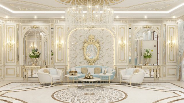 This picture shows a luxurious living room with a contemporary design. The room features a pair of velvet armchairs with gold accents and plush cushions, a round marble coffee table, white bookcases filled with books, a crystal chandelier, an area rug with an intricate pattern, and a large painting mounted on the wall.