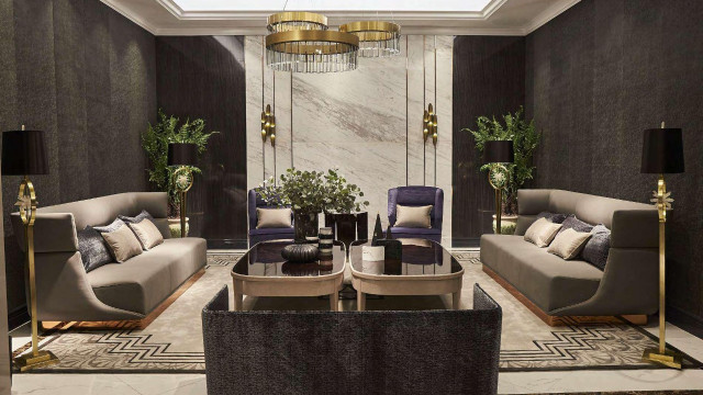 Modern hotel lobby featuring an illuminated reception desk, lounge seating area with sofas and armchairs, and a grand spiral staircase leading up to a luxurious mezzanine.