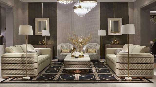 Modern luxury living room featuring a curved couch, center table, patterned area rug, and several accent pillows.