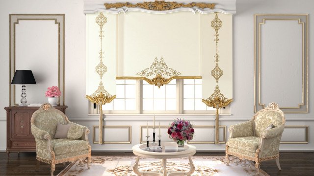 This picture shows a modern, luxurious living room design. It features a large white leather sectional sofa with gold-accented armrests and golden details throughout the room. The walls are painted in a light grey color with a subtle wood pattern. The furniture is upholstered with a beige and floral pattern fabric, and there are gold fixtures for the light fixtures and accent pieces. There is a large round coffee table in the center of the room with a glass top, and it is surrounded by several small accent tables. The room is decorated with art hung on the walls