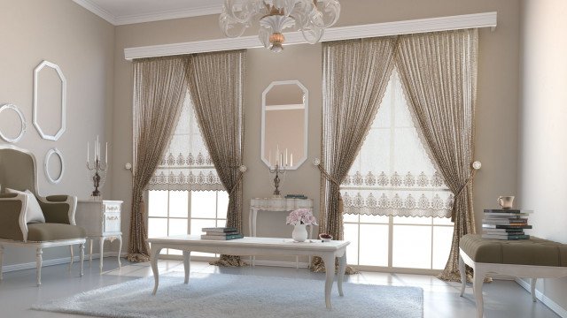 This picture shows a beautiful and luxurious living room. The spacious room features luxurious pale gray leather furniture, with intricate gold details. There is also an elegant chandelier in the center of the room, along with a subtle dark wood furniture set that stands against a white wall. In the center, a large crystal vase holds some yellow flowers, adding a touch of color to the modern and luxurious decor.