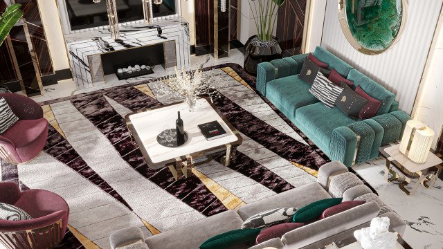 This picture depicts a modern and luxurious living room in shades of white and blue. In the center, there is a light blue velvet couch with a few gold and cream throw pillows. There is a large round blue rug on the floor beneath the couch, and on one side stands an ornate white cabinet with two doors with detailed scrolling carvings. On the walls are white paneled shelves that are each filled with home decor items such as vases, books, and statuettes. The room is illuminated by light coming in through two large windows, as well as a crystal ch