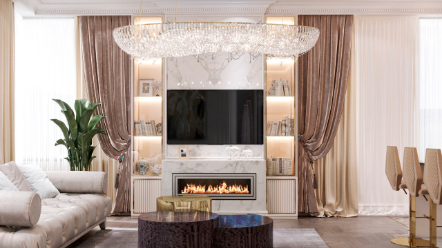 This picture shows an elegantly designed sitting room. The room has a large, U-shaped sectional sofa with a navy and light grey pattern, accompanied by two matching armchairs and a round ottoman. The walls are painted white and have several large windows and crystal wall sconces. The floor has been covered with a white and grey patterned rug, while the ceiling has recessed lighting. The room also features a modern fireplace and a large plants on both sides of the room.