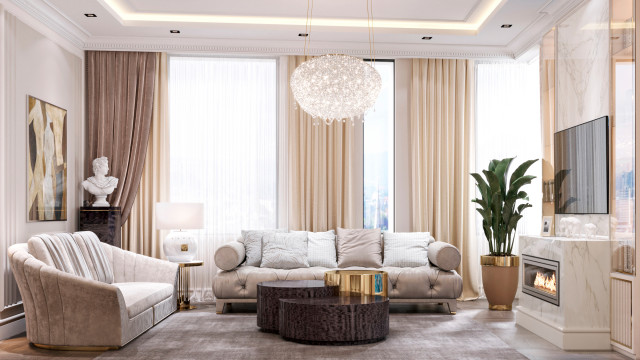 This picture is showing a luxurious living room in shades of purple and blue. The room features an ornate fireplace, a curved velvet sofa, a crystal chandelier, and various pieces of art adorning the walls. An area rug in shades of pink and purple and two end tables complete the look.