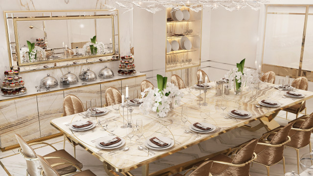 This picture shows a luxury dining room, featuring a stunning light fixture with intricate curved metal details, and a marble-topped wooden dining table. The walls are decorated with beautiful ornate wallpaper, and offset by white wainscoting and wood trim. The room has two classic French chairs upholstered in a white and gold fabric, and is completed with an elegant rug to finish the look.