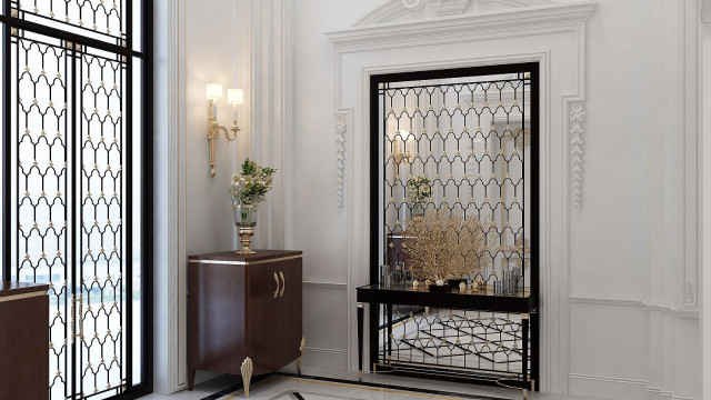 This picture shows an elegant white marble floor with a gold and mirrored inlay pattern. The pattern features intricate and interlinking shapes, surrounded by a decorative border. The overall design is luxurious and grand, creating an impressive look for this space.