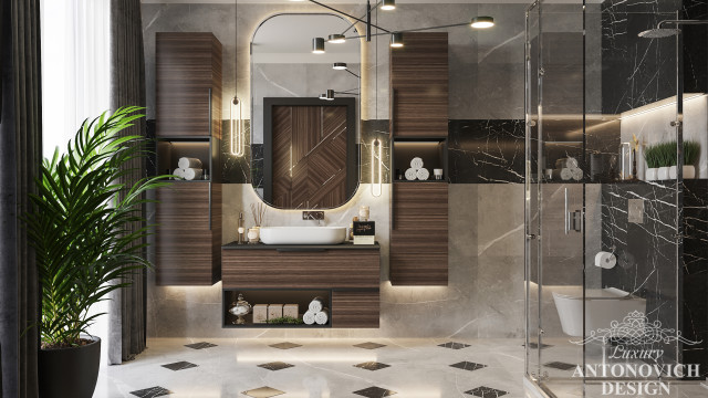 The modern bathroom radiates style and luxury, featuring a statement mirror, mosaic tiles, and glistening gold fixtures.