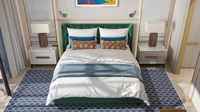 This picture shows a modern and luxurious bedroom. The room features a white and grey color palette that is decorated with golden accents. The walls are covered in light grey wallpaper with a geometric print and there are large windows that let in tons of natural light. In the center of the room is a large white leather bed with two nightstands on either side and a grey tufted headboard. The room has wooden floors and a unique rug in the corner that adds a touch of warmth. The room also has a white dresser and an armchair next to the bed.