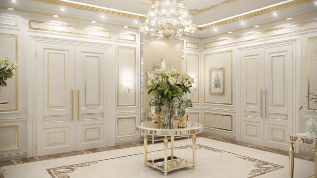 This picture shows a stunningly luxurious interior design for a dining room. It features an elegant dark wood dining table with a white marble top and gold accents, four matching upholstered chairs in light fabric with gold accents along the edges, a modern white chandelier hanging above the table, and an intricately designed ceiling with gold and cream patterns. The walls are also decorated in light colors and subtle golden details, and a large window provides plenty of natural light.