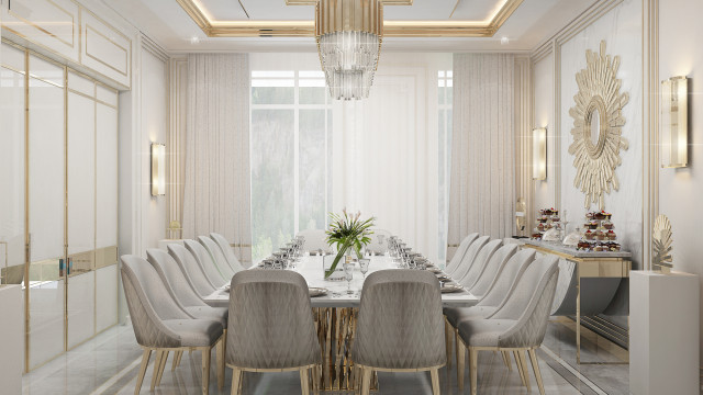 This picture shows an indoor area with a white marble floor, white walls, and recessed hallway lighting. It has a double doorway entrance with an ornate silver accent along the top of the entryway. A beautiful set of sofas and armchairs are arranged in a semi-circle pattern, with a center coffee table and two decorative chairs placed near the entrance. A large wall mirror is also featured near the windows, with two round side tables on either side.