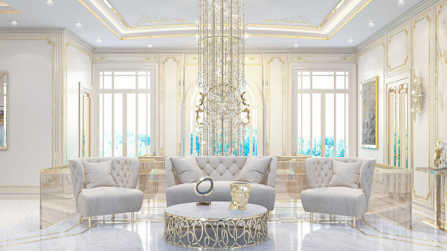 The picture shows a luxurious home interior design. It includes a large, curved white sofa, surrounded by floor-to-ceiling windows that offer plenty of natural light. The room is decorated with intricate gold and crystal chandeliers, along with elegant, beige drapery. There is a contemporary wooden coffee table in the center of the room, topped with a stunning centerpiece arrangement of tall flowers. The space is finished off with an impressive series of art pieces hung on the walls.