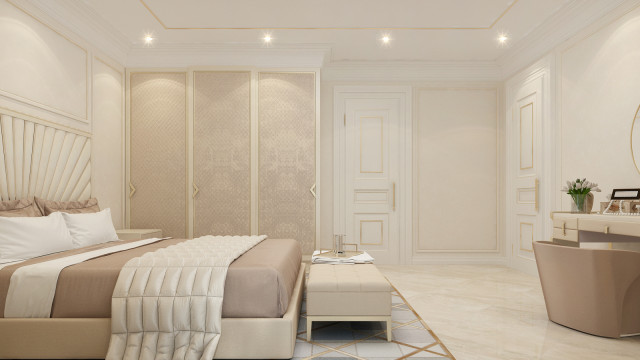 This picture shows a luxurious and elegant bathroom adorned with marble fixtures, dark wood accents, and metallic details. The center of the room features a large white bathtub, flanked by a pair of matching vanities with granite tops. Above the tub hangs a beautiful modern crystal chandelier as well as two ornate sconces, adding to the overall glamour of the space. A set of French doors provide access to the adjacent bedroom.