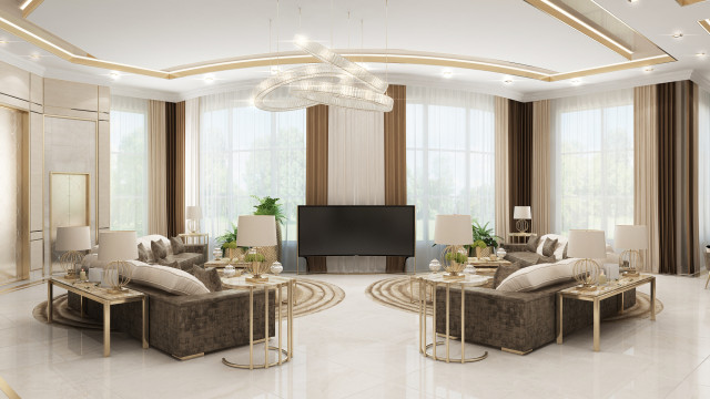 The image shows a luxurious living room with an impressive modern design. The room is furnished with a white leather sectional sofa, a dark glass coffee table, and two white armchairs. The walls are painted in a light grey color and are adorned with two abstract paintings. A large area rug covers the wood floor, adding warmth and texture to the space. Rows of recessed lighting provide subtle illumination while a panel of wide windows allows natural light to enter.