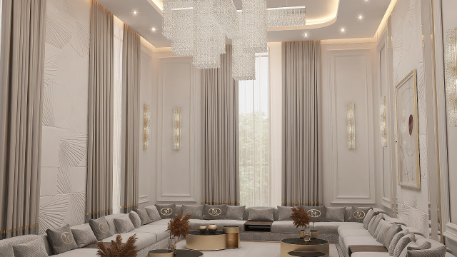 This picture shows an opulent living room designed by Antonovich Design. The room features a large sectional sofa upholstered in velvet, elegant curtains framing the windows, a marble fireplace mantel, and two ornate upholstered accent chairs. A crystal chandelier hangs above the seating area, while a grand piano rests in the corner of the room. The walls are painted a deep burgundy color, and the floor is covered with a large white area rug.