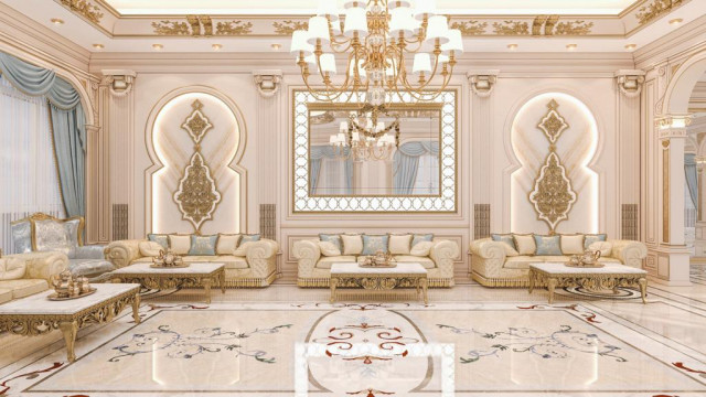 This picture shows a luxurious bathroom interior design. The bathroom is decorated with golden accents, marble, and other modern fixtures. The walls are a light grey color with a large mirror along the bathtub and a glass enclosed shower. There is also a white porcelain sink and a cream-colored vanity with a matching marble countertop. The floor is covered in an elegant white tile which creates a vibrant and inviting atmosphere.