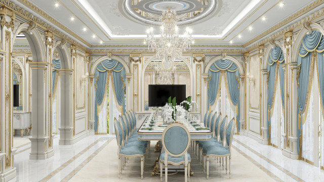 This is a highly-decorated luxury living room designed by Antonovich Design. The room has a marble floor, large white sofas, white and gold mirrored walls, and a large round crystal chandelier hanging from the ceiling. There is an ornate gold table in the center of the room and two stylish armchairs upholstered in white leather. On the right side of the room, is a built-in bookcase with ornate frames and decorative shelving, and on the left-hand side, is a large window with white drapes that let