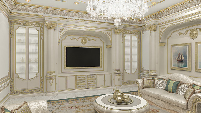 This picture shows an ornately designed living room with an elegant white sofa and two armchairs upholstered in a white-and-gold fabric. The walls are covered in a cream-colored silk wallpaper and the ceiling features a soffit with a design of intricate golden scrolls. There is a textured white rug on the floor and a stunning crystal chandelier hanging from the ceiling. In front of the sofa is a marble-topped coffee table with a beautiful floral centerpiece.