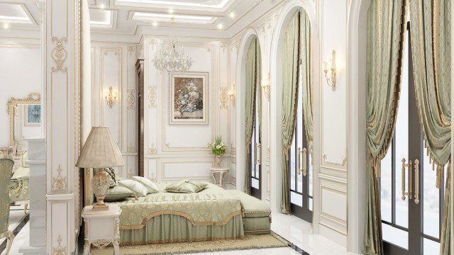 The picture shows a luxurious living room with predominantly white and gray furniture and décor. The room includes an elegant white armchair, a white sofa, a plush gray ottoman and two matching side tables. On the walls there is an intricate gold framed mirror, as well as large windows dressed in beautiful sheer curtains. An ornate crystal chandelier hangs from the ceiling, adding to the room's overall opulent atmosphere.