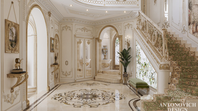 This picture is of an ornately decorated private apartment in an luxurious style. The room is filled with designer furniture, plush carpets, and lavish drapery. There is a large chandelier suspended from the ceiling and intricate details on the walls and carpet. The room is full of warm colors and has a cozy, inviting feel.
