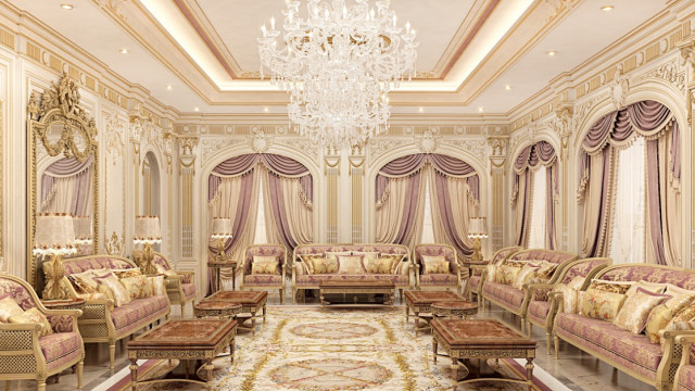 Luxurious living room with white walls, floors, and furniture; large rug with intricate pattern; light fixtures; glass coffee table; decorative accents.