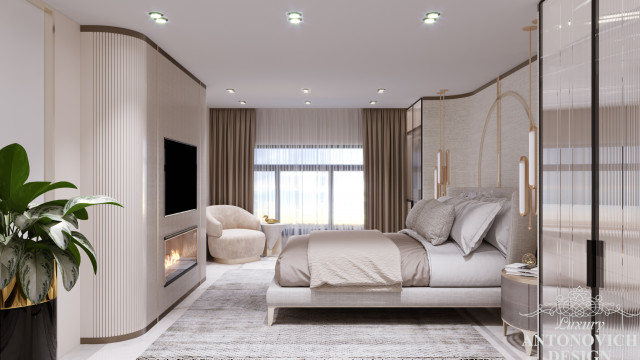 This picture shows a luxury bedroom interior in a modern style. The room has light beige walls and flooring, complemented by elegant mahogany furniture and marble accents. There is a large four-poster bed with white linens and an ornate headboard, along with several upholstered chairs and ottomans. An elaborate crystal chandelier hangs from the ceiling, and various pieces of art hang on the walls. In addition, the space is illuminated by two decorative wall sconces on either side of the bed.