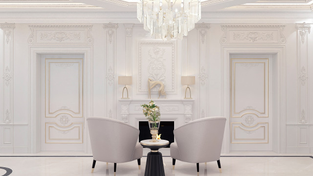 This photo shows a modern living room designed by Antonovich Design. The room features white walls, a light gray tiled floor, and a white leather sofa with metallic accents. In the center is an oval-shaped coffee table with a black base and top, surrounded by four comfy armchairs upholstered in a rich blue fabric. The walls are adorned with a contemporary abstract art piece and two large windows that provide plenty of natural light. The color scheme is calming and neutral, giving this space a glamorous yet inviting atmosphere.