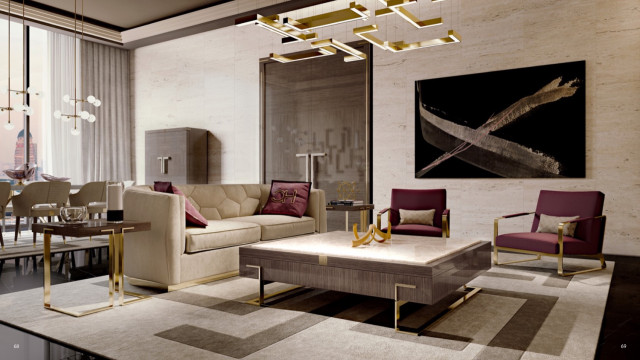 This picture shows an elegant, modern living room. The room features a glass coffee table and two gray velvet armchairs. The walls are painted gray and the floor is covered in a white rug, with a dusty pink and gray area rug layered on top. There is a large painting hung on the accent wall, which adds a dramatic visual element to the room. A sleek glass divider separates the living area from the kitchen area, where a white countertop and cabinets can be seen.