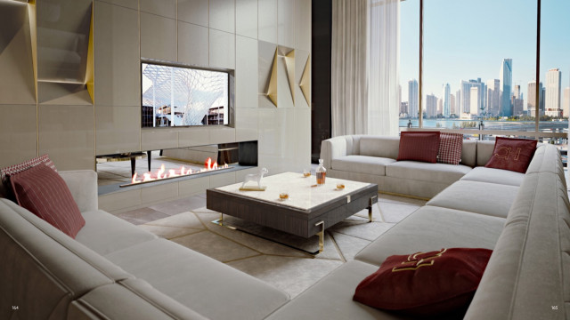 jpgThis picture shows a modern and luxurious living room that is designed with a warm and neutral colour palette. The room features a large beige velvet sofa that sits in front of a large window. There is a wooden coffee table in the center of the room and a dark wooden sideboard against the wall. The floor is covered with a white shaggy rug and a large silver round mirror hangs on the wall. The walls are painted in a light grey colour and adorned with abstract art pieces.