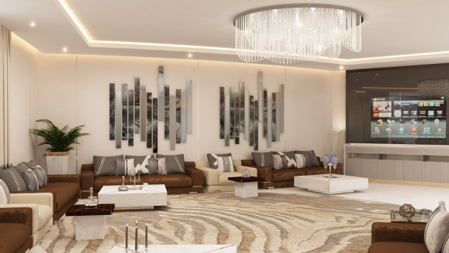 This picture shows a modern and luxurious apartment dining area. The room has light grey walls and dark wood floors, decorated with a white and black area rug. The dining table is surrounded by six chairs upholstered in white, and it is accented with a silver and crystal chandelier. An elaborate, patterned wallpaper of abstract shapes frames the space, with two large windows looking out onto the cityscape beyond.