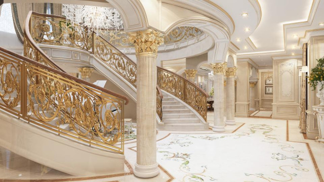 Luxury living space, featuring a curved sofa in neutral tones, an ornate fireplace, and an intricate multi-level chandelier.