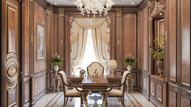 This image is of a luxurious living room space featuring a classic and timeless design. The space includes a white tufted sofa with gray pillows, a gray velvet armchair, a luxurious rug, and two glass-top coffee tables. The walls are painted in a warm gray color, while the floor is light beige. There is an ornate fireplace with a black marble surround, and a large chandelier hangs from the ceiling. There are also several pieces of classic artwork on the walls.