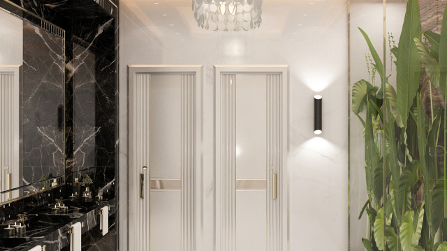 This picture shows an elegant interior design featuring a grand entrance with a large, ornate doorway. The door frame is decorated with beautifully detailed molding and a white marble floor extends out beyond the door, into a hallway that leads further into the home. The walls are painted a light gold color and the ceiling features a stunning chandelier with crystal accents.