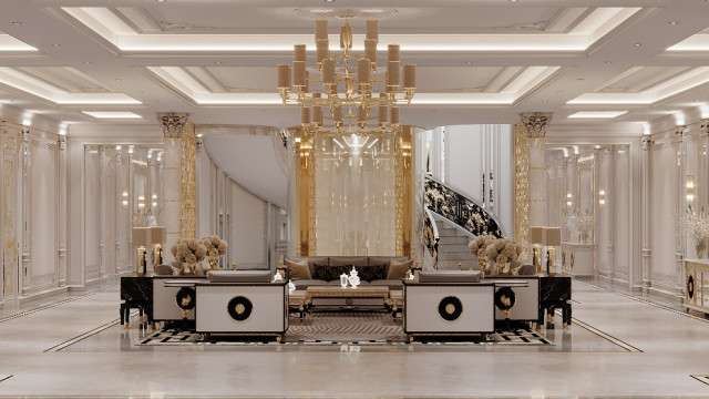 This picture is of a luxurious living area designed by Antonovich Design. The room features an array of marble and granite features, such as the built-in fireplace and decorative column frames. The space also has a comfortable seating area, with a large sofa and two armchairs arranged around a glass coffee table. A round rug anchors the area and a coordinating chandelier hangs overhead providing a warm glow. Decorative pieces are used throughout the design to complete the look, such as a tall vase and intricate accent lamps.