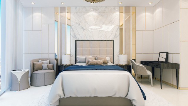 A modern luxury living room featuring a white leather sofa and armchair, a black and white rug, white walls with art, and a statement chandelier.