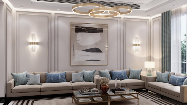 This picture shows an elegant and modern living room. The neutral color palette sets off the sleek pieces of furniture, including a white sectional sofa, a walnut coffee table, and two tan armchairs. There is also an accent wall featuring a geometric pattern in shades of grey and beige. On one side of the room, a glass sliding door opens to a balcony revealing a stunning outdoor view.