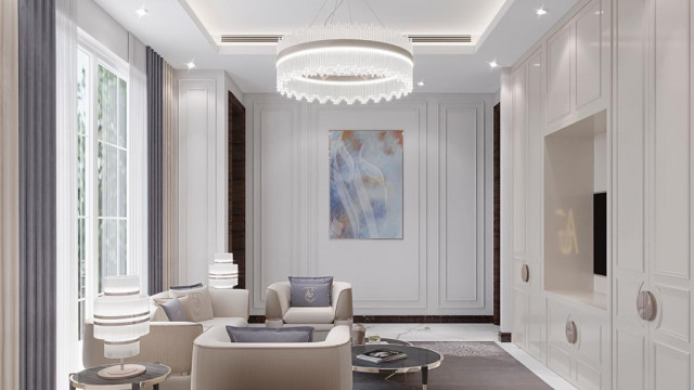 This picture shows an elegant and luxurious hallway in a home. The hallway features white marble flooring, with decorative designs on the walls and ceiling. The walls are lined with marble pillars and a grand chandelier hangs from the center of the hallway. At the end of the hallway, there is a set of ornate double doors.