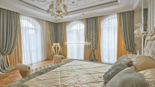 Luxurious room featuring an elegant red and white sofa set, ornate gold chairs, and elaborate golden curtains.