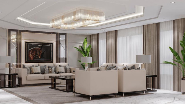A luxury living room with beige walls, a fireplace, and a white ceiling decorated with elegant Molding. Large armchairs and a sofa are arranged around a luxurious center table.