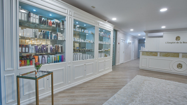 A large, modern wooden double door entrance with decorative windows and intricate carvings around the frame.