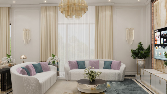 The image displays a contemporary living room with a classic balcony view and luxury furniture. The room is filled with soft tones in the furniture and carpet, accented with natural wood accents, and with a central chandelier and grand mirror providing an elegant touch.