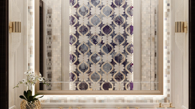 This picture shows a luxurious, modern bathroom with elegant fixtures. The walls of the bathroom are painted in a light grey color, with a white marble tile floor. The vanity is a large double-sink unit with a modern granite countertop and a large mirror above it. The shower area has beautiful glass doors, along with luxury chrome showerhead and fixtures. In addition, there is a comfortable seating area next to the vanity, with a plush chair and a small side table.