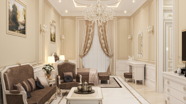 This picture is a photo of a luxurious living room with a sofa, armchair and an accent chair in cream and gray colors. The walls are covered with ornate wallpaper, and there is a light gray area rug on the floor. There is a large window with white wooden shutters, and a round coffee table in the middle of the room, adorned with a gold vase, a white candle, and a brown leather-bound book. On the left side of the room is a marble fireplace with a large painting above it.