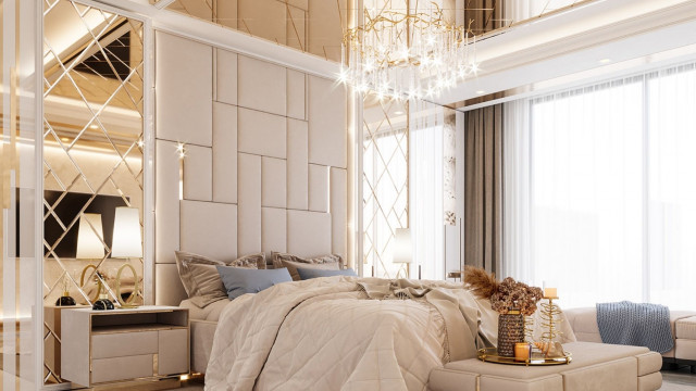 This picture shows a grand marble foyer in an interior design. The room has a high, vaulted ceiling with an elaborate blend of two types of marble, black and white, running across the walls and floors. An oversized crystal chandelier hangs in the center of the room, and luxurious furniture pieces, such as chairs and a chaise lounge, are arranged around the perimeter.