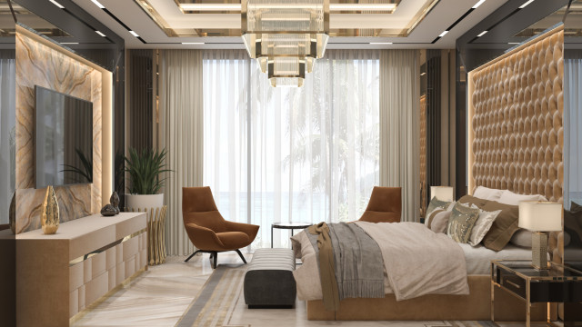 This picture shows a modern and stylish bedroom interior. It features a white bed with a black headboard, two matching end tables, and a chandelier hanging above. The walls are painted white and feature two large abstract art pieces in pink, blue and black. There is also a white tufted ottoman at the foot of the bed and a side table with a white lamp and flower vase. The floor is grey and has a patterned rug.