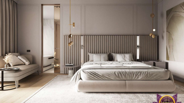 Modern bedroom interior with king-size bed, bedside tables and lamps, upholstered armchair, large wooden wardrobe, and patterned rug.