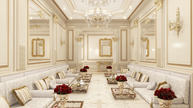 This picture shows a luxurious living room designed by Antonovich Design. The room has a modern and elegant style, with soft cream and beige tones emphasized by natural wood finishes. There is a sectional sofa set against a large wall featuring a large flat-screen television and an intricate stone fireplace. The walls are adorned with sophisticated paintings and beautiful sconces, while the floor is covered with a unique patterned rug. The furniture is highlighted by an ornate crystal chandelier that hangs from the ceiling above the sofa.