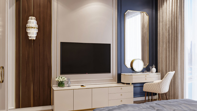 This picture shows a luxurious master bathroom with large windows and great views. The walls are tiled with beautiful cream-colored marble, while the floor is also tiled with matching marble that is a combination of light brown and golden beige. The bathroom has a large shower area and a freestanding bathtub with a nearby lounge area, perfect for relaxing. There are two wall-mounted counters with lavatories, as well as two separate dressing tables in the center of the room. There is also a chandelier with overhead lighting, adding a touch of elegance to the space.