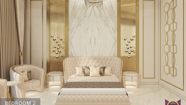 This picture shows a modern and luxurious interior design of a living room. It features a cream-colored sofa set situated on an ivory rug with a small round coffee table in the center. The room also includes ornate chandeliers hanging from the ceiling, as well as wall sconces and a large abstract painting. There are also long white drapes which lead to floor-to-ceiling windows, allowing for natural light to fill the space.