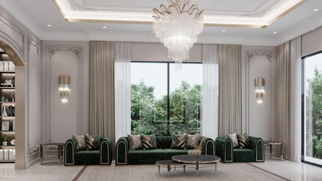 Contemporary living room with grey sofas, beige armchairs, stone fireplace and large windows.