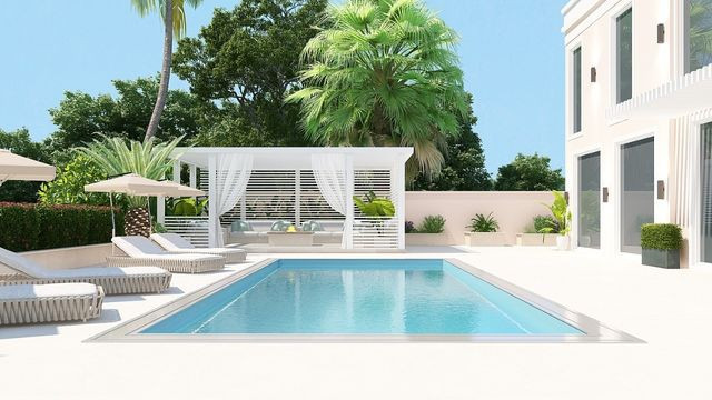 Luxurious, white room featuring a modern sitting area with a large sofa, armchair and coffee table.